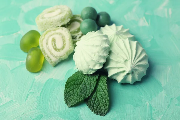 Merengues y caramelos de color menta sobre fondo de color —  Fotos de Stock