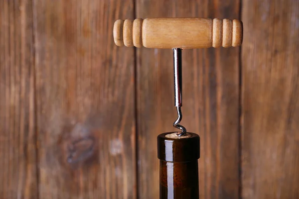 Abridor de botellas de cerca, sobre fondo de madera —  Fotos de Stock