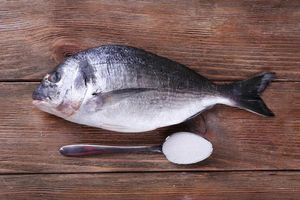 新鮮な魚と木製の背景にスプーンの塩 — ストック写真