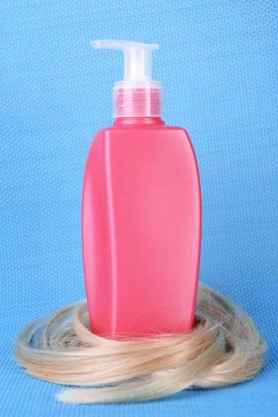 Shampoo with curly blond hair on blue background — Stock Photo, Image