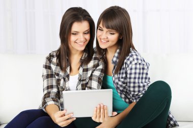 Güzel kızlar İkizler elektronik tablet kanepe ile