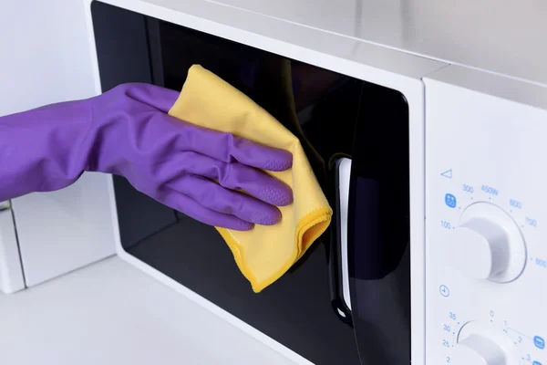 Cleaning microwave oven in kitchen close-up — Stock Photo, Image