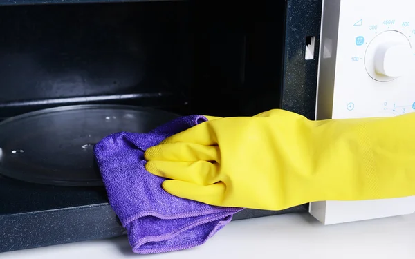 Cleaning microwave oven in kitchen close-up — Stock Photo, Image