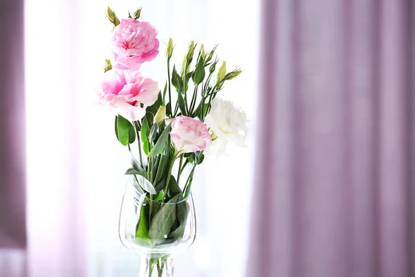 Mooie bloemen in vaas met licht uit raam — Stockfoto