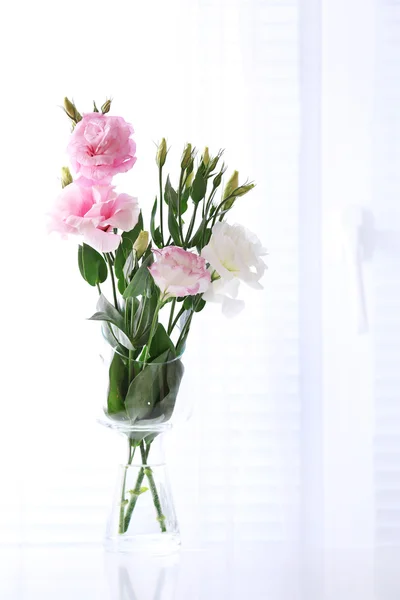 Beautiful flowers in vase with light from window — Stock Photo, Image