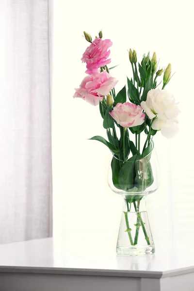 Mooie bloemen in vaas met licht uit raam — Stockfoto