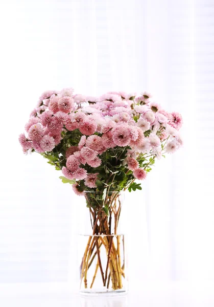 Beautiful flowers in vase with light from window — Stock Photo, Image