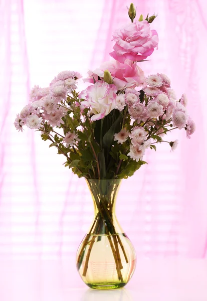 Mooie bloemen in vaas met licht uit raam — Stockfoto