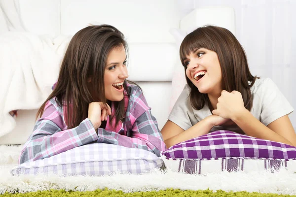 Beautiful girls twins in pajamas with pillows at home — Stock Photo, Image