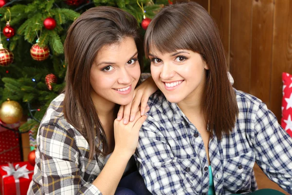 Vackra flickor tvillingar nära julgran hemma — Stockfoto