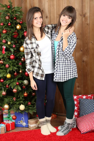 Beautiful girls twins near Christmas tree at home — Stock Photo, Image