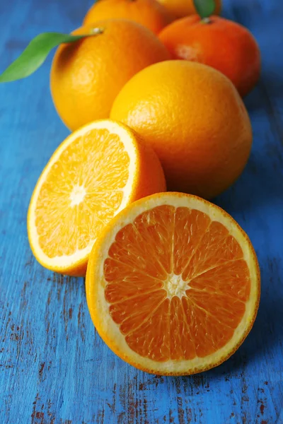 橘子和橙子有叶子的木制背景 — 图库照片