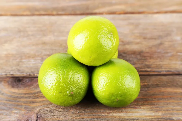 Frische saftige Limetten auf Holzgrund — Stockfoto