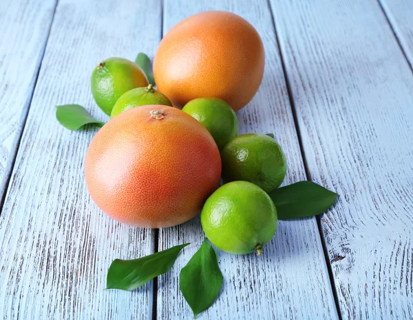 Спелые грейпфруты и лаймы на деревянном фоне — стоковое фото