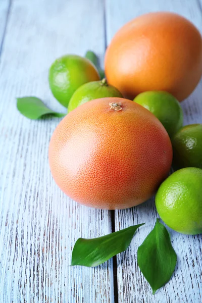 Rijp grapefruits en limoenen op houten achtergrond — Stockfoto