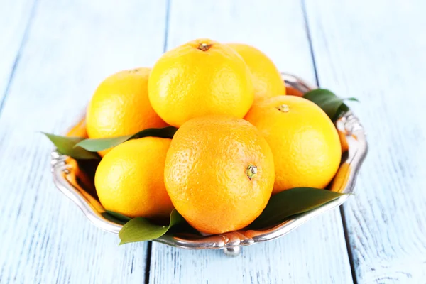 Tangerines with leaves on plate — Stock Photo, Image