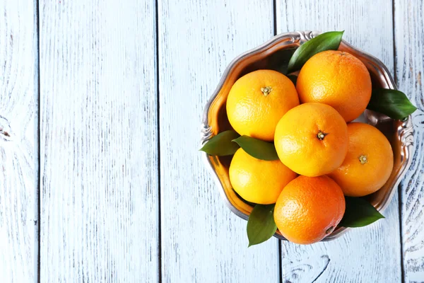 Tangerines with leaves on plate — Stock Photo, Image