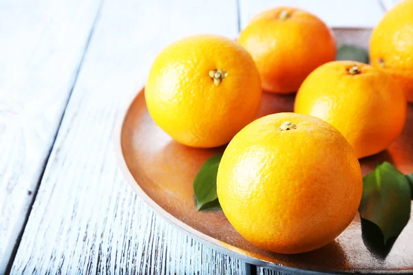 Tangerinas com folhas na placa — Fotografia de Stock