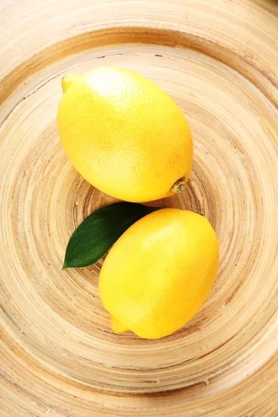 Citrons mûrs sur assiette en bois close-up — Photo