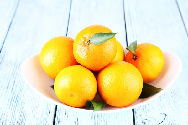 Tangerinas com folhas na placa — Fotografia de Stock