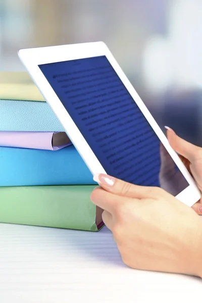 Vrouwelijke hand met Pc Tablet PC in de buurt van boeken, close-up. Moderne onderwijs concept — Stockfoto