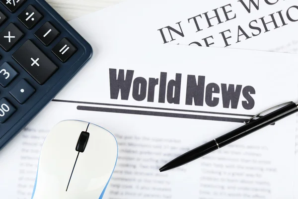 On-line news and business concept. Computer mouse, calculator and newspaper on wooden table background — Stock Photo, Image