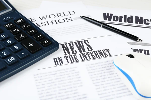 On-line news and business concept. Computer mouse, calculator and newspaper on wooden table background — Stock Photo, Image