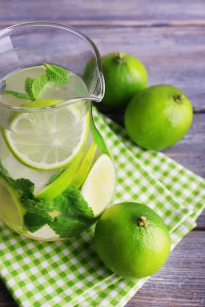 Lemonade in pitcher on wooden background — Stock Photo, Image