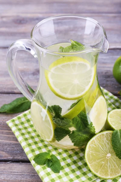 Lemonade in pitcher on wooden background — Stock Photo, Image