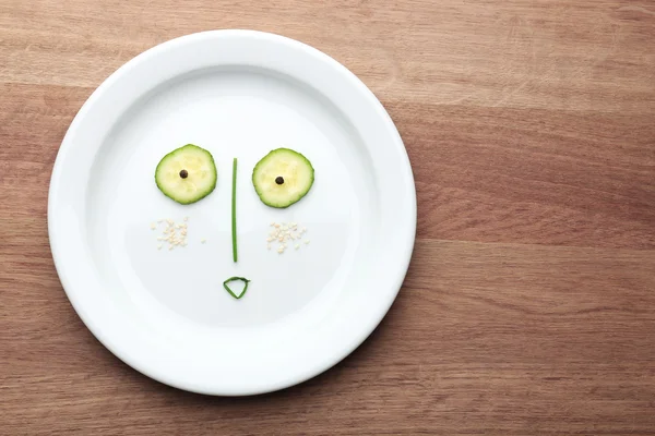 Овощное лицо на тарелке — стоковое фото