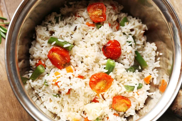 Tasty rice in pan on wooden table — Stock Photo, Image