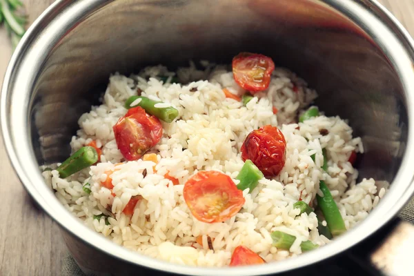 Riz savoureux dans une casserole sur table en bois — Photo