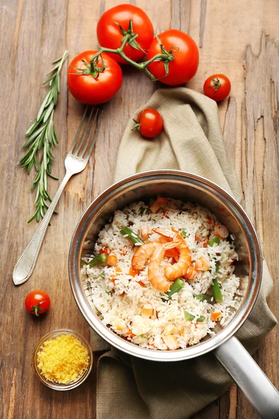 Ahşap masa üzerinde tavada lezzetli pirinç — Stok fotoğraf