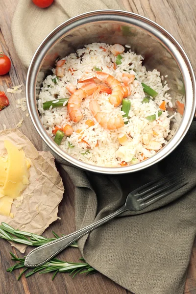 Tasty rice in pan on wooden table — Stock Photo, Image