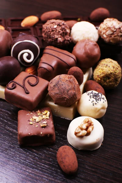 Group of sweet chocolate truffles on the dark wooden smooth background — Stock Photo, Image