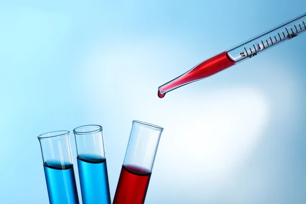 Pipet kırmızı sıvı test tüpleri açık renkli üzerinde bir ekleme — Stok fotoğraf