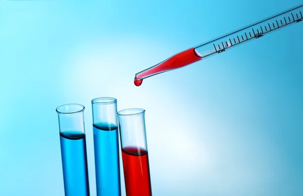 Pipet kırmızı sıvı test tüpleri açık renkli üzerinde bir ekleme — Stok fotoğraf