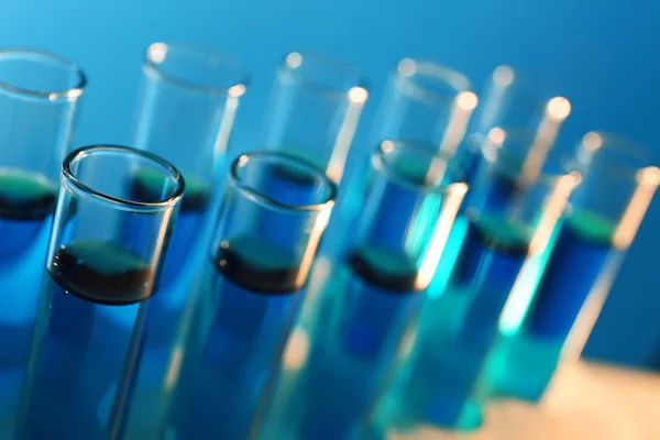 Test-tubes filled with blue and red fluid on the muted background — Stock Photo, Image