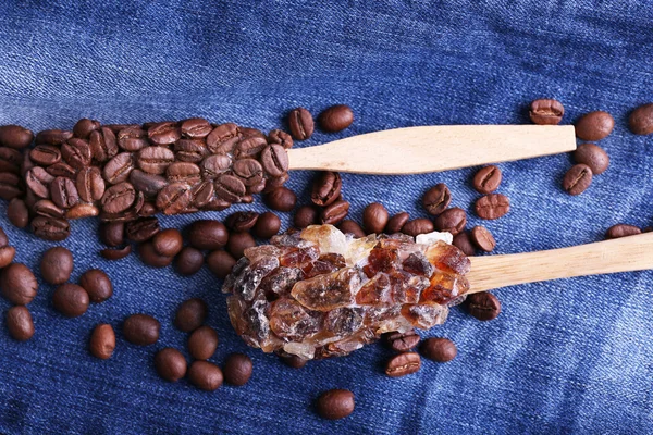 Cucharas de madera pegajosas con granos de café y cristales de fondo vaquero —  Fotos de Stock
