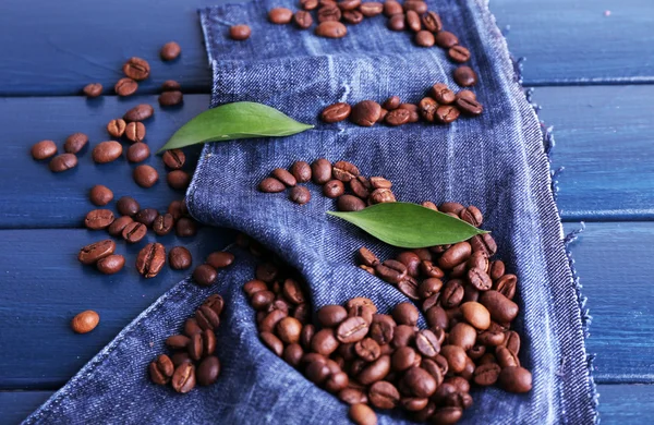 Grüne Blütenblätter mit Kaffeebohnen — Stockfoto