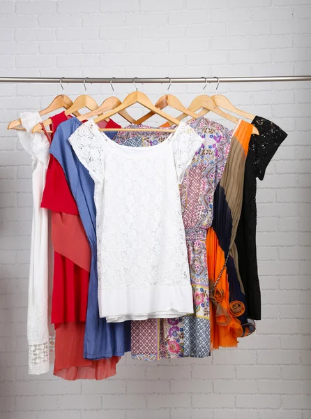 Kvinnliga klänningar på galgar i rum — Stockfoto