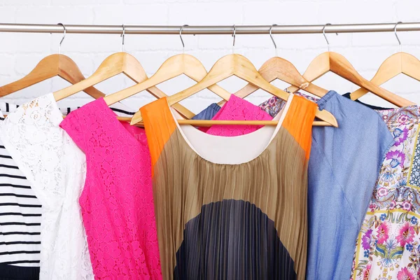 Frauenkleider auf Kleiderbügeln im Zimmer — Stockfoto