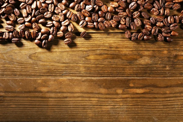 Granos de café sobre fondo de madera —  Fotos de Stock