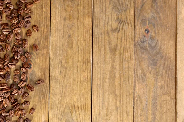 Grãos de café em fundo de madeira — Fotografia de Stock