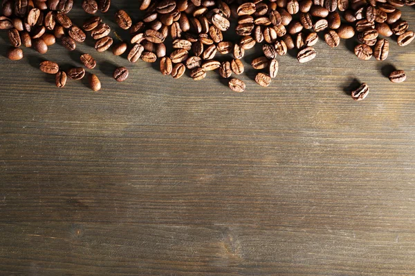 Grãos de café em fundo de madeira — Fotografia de Stock