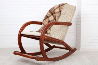 Ekose tuğla duvar arka plan yakınındaki ahşap zemin üzerinde sallanan sandalye kaplı