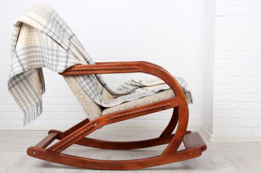 Ekose tuğla duvar arka plan yakınındaki ahşap zemin üzerinde sallanan sandalye kaplı