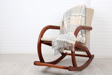 Ekose tuğla duvar arka plan yakınındaki ahşap zemin üzerinde sallanan sandalye kaplı