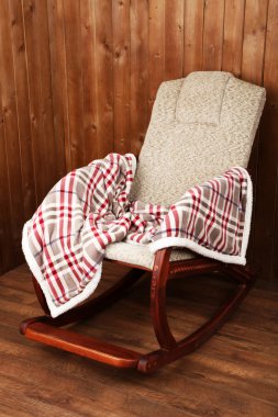 Sallanan sandalye ahşap duvar arka plan üzerinde ekose kaplı