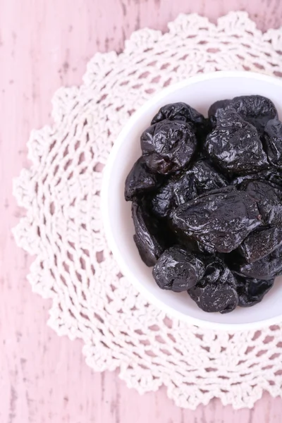 Prunes in bowl on lace — Stock Photo, Image
